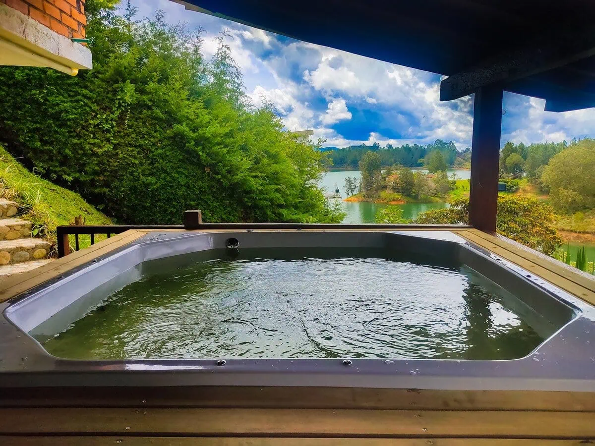 Hot tub with scenic lake and greenery views